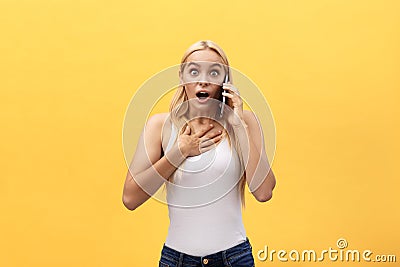 Image of gorgeous woman in casual being surprised or excited to receive pleasant talk on her cell phone, over yellow Stock Photo