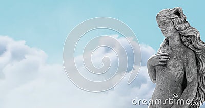 Image of gray sculpture of woman over blue sky and clouds, copy space Stock Photo