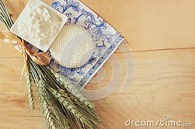 Image of greek cheese , bulgarian cheese and milk on wooden table over vintage rustic background. Symbols of jewish holiday - Stock Photo