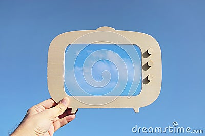 image of hand holding tv frame in front of sky with cloud. capture the moment or minimal concept. Stock Photo