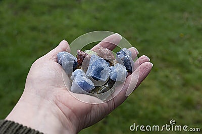 Hand Holding Several Small and Colorful Calcite Crystals Stock Photo