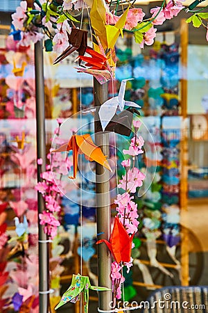 Hanging paper cranes with pink cherry blossom flowers background asset Stock Photo