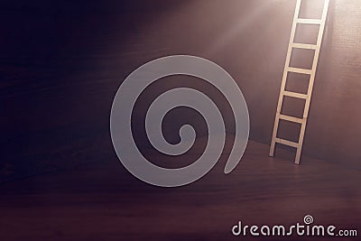 Image of ladder over dark wooden wall with light. concept of hope, faith, religion and success Stock Photo