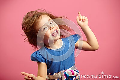 Image of little dancing girl wears beautiful dress on isolated pink background. Stock Photo