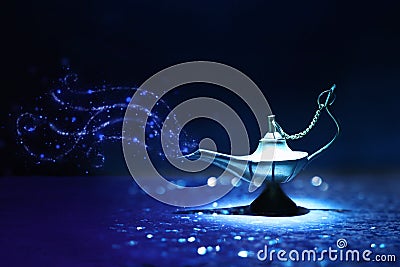 Image of magical mysterious aladdin lamp with glitter smoke. Dark background and dramatic light Stock Photo