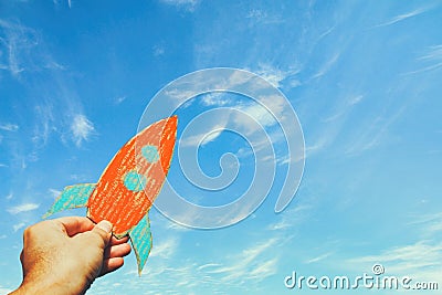 Image of male hand holding a rocket against the sky. imagination and success concept. Stock Photo