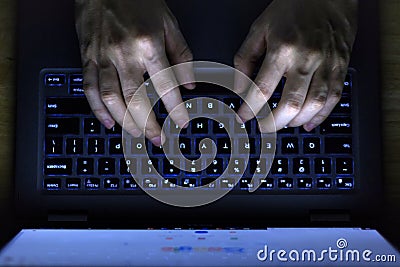 Hands Typing Laptop Keyboard In The Dark Stock Photo