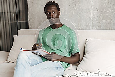 Image of african american man studying with exercise book at home Stock Photo