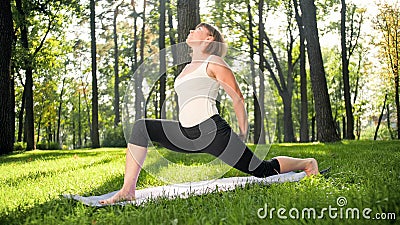Photo of middle aged smiling woman practising yoga asana. Persong meditating in nature. Balance and harmony of body and Stock Photo