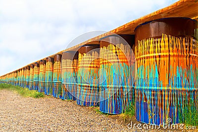 Image of multi-colored, rusty and old oil barrels in piles with a blue sky and sunny day. barrels perspective, like a Stock Photo