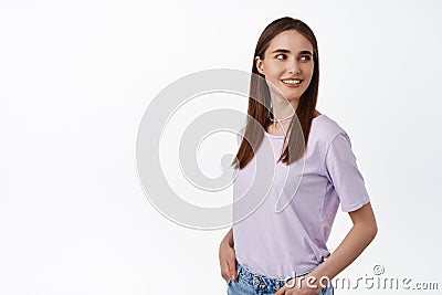 Image of natural young woman with candid smile, turn head and look behind shoulder at promo text, staring at banner with Stock Photo