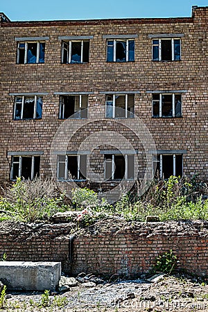 An image of part of an abandoned red brick factory building with broken glass Stock Photo