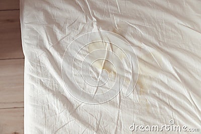 Image of pee on the white bed sheet. Cause stains and dirty on the mattress. Stock Photo