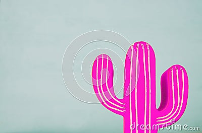 Image of pink neon cactus decoration infront of wooden blue background. Stock Photo