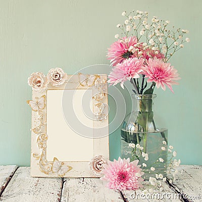 Image of pink and white flowers and antique frame on wooden table. template, ready to put photography Stock Photo