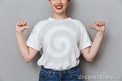 Image of pleased brunette woman smiling and pointing fingers at herself Stock Photo