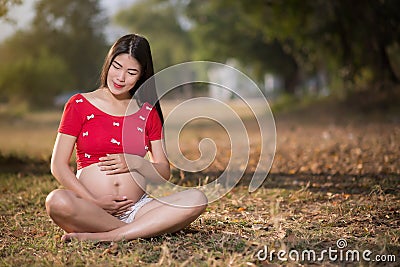 Image of pregnant woman touching her belly with hands Stock Photo