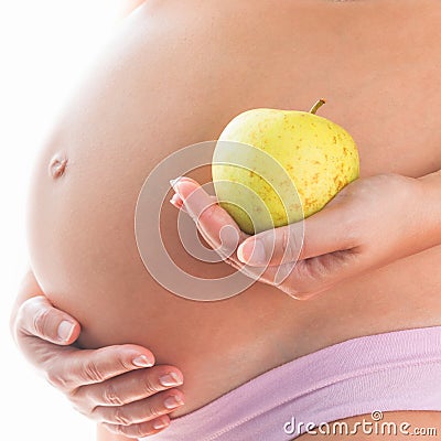 Image of pregnant woman touching her big belly and holding green apple in the hand isolated on white background. Stock Photo