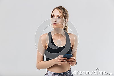 Image of pretty blond woman 20s dressed in sportswear using smartphone during workout in gym Stock Photo
