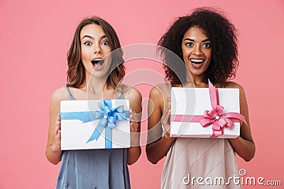 Pretty shocked young two women holding gifts Stock Photo