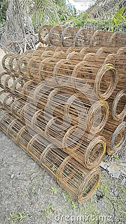 Roll up rusty steel rebar grid reinforcement frame lying on the ground for building construction usage. Stock Photo