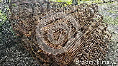 Roll up rusty steel rebar grid reinforcement frame lying on the ground for building construction usage. Stock Photo