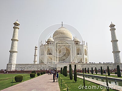 Image of seven wonder of world the Taj Mahal located in Agra. White marble indian beautiful Mughal monument surrounded by tourists Stock Photo