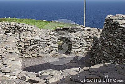Ancient stone beehive hut colony of clochans, stone dry huts in rural Ireland Stock Photo