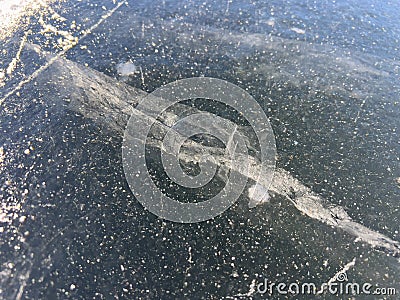 A close-up view of a frozen surface with visible cracks and bubbles, capturing the intricate details and natural patterns of the Stock Photo