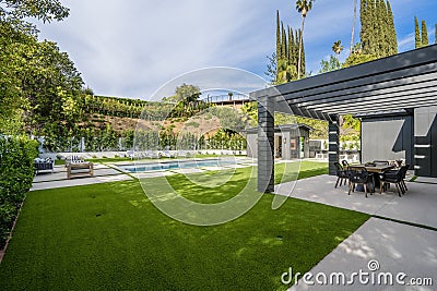 Image shows an outdoor patio overlooking a stunning swimming pool Editorial Stock Photo