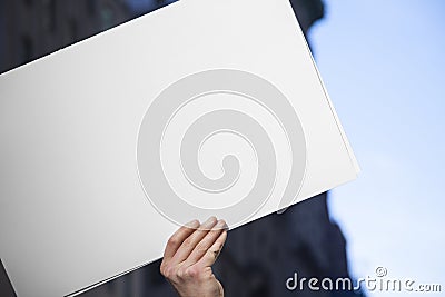 Blank White Protest Sign Hand with Urban Background Stock Photo