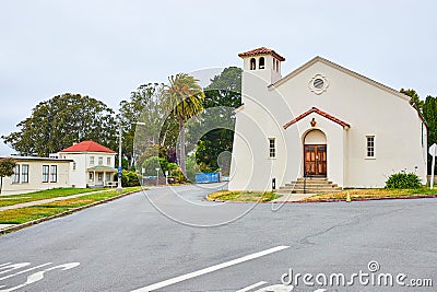 Simple white church with road splitting off to either side of it Stock Photo