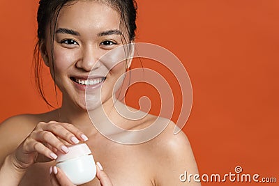 Image of smiling shirtless asian girl posing with facial cream Stock Photo