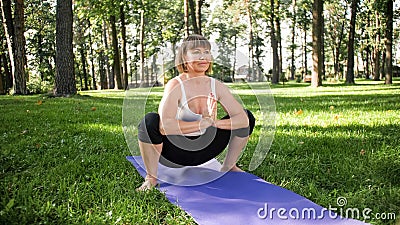 Photo of smiling woman doing yoga and fitness exercises. Middle aged people taking care of their health. Harmony of body Stock Photo