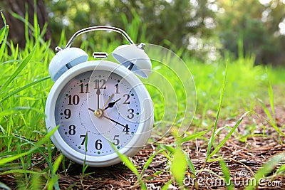 Image of spring Time Change. Summer back concept. Vintage alarm Clock outdoors. Stock Photo