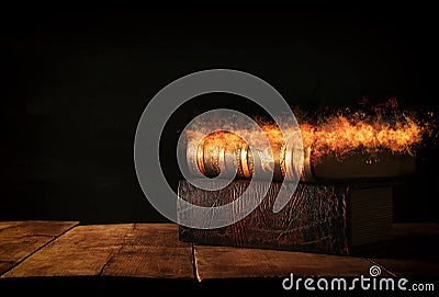 image of stack of antique books over wooden table and dark background. Stock Photo