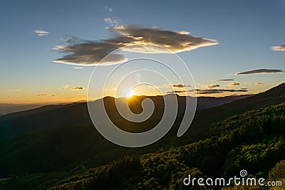 Image of the sun falling behind the mountains Stock Photo