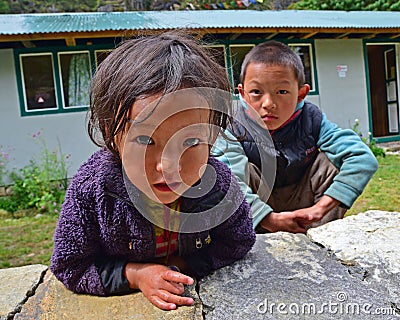 Nepalese kids trying to be friendly in front of their home in a village along Everest Base Camp, Nepal Editorial Stock Photo