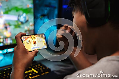 Image of teenage gamer boy playing video games on smartphone and Stock Photo