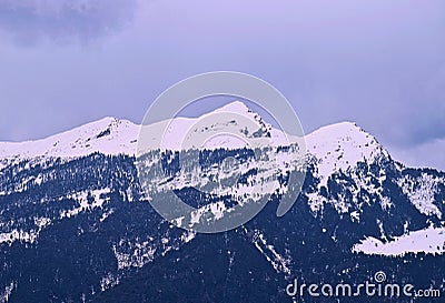 Three Himalayan Peaks of Shivalik Range - Blue Mountains Covered by White Snow with Cloudy Sky in Background - India, Asia Stock Photo
