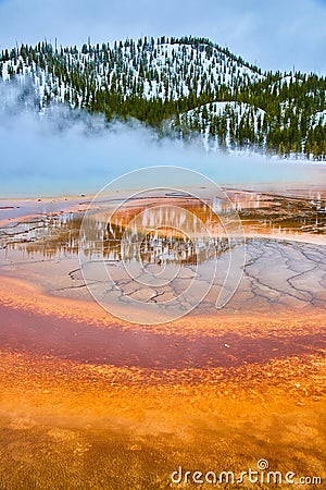 Winter at Yellowstone with stunning red and orange layers by steamy spring Stock Photo