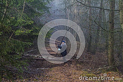 Image of a woman asking if she can follow a path that is obstructed by fallen tree trunks Stock Photo