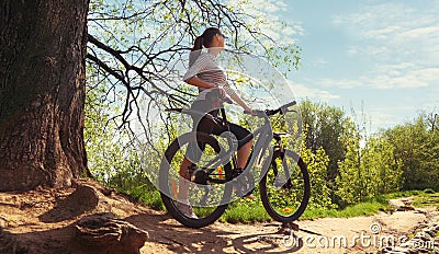 Image of woman with bicycle in a park Stock Photo