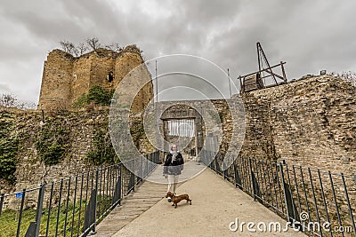 Image of a woman with her dog on the bridge leading to the entrance of the castle Franchimont Editorial Stock Photo