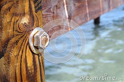 Image of the wood, the bolt, nut in the pier at sea . Stock Photo