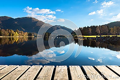 Wood Texture and Beautiful Autumn Landscape Background with Colorful Trees, Mountains, Clouds in Blue Sky and Lake Reflection Stock Photo