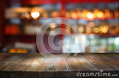 Image of wooden table in front of abstract blurred background of restaurant lights Stock Photo