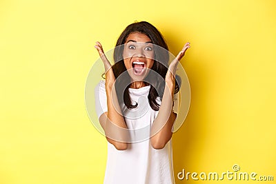 Image of young african american woman looking annoyed, screaming bothered and angry, standing over yellow background Stock Photo