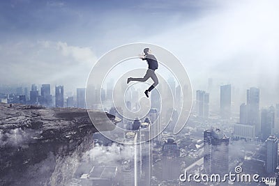 Young businesswoman jumping off a cliff Stock Photo