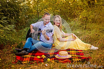Young man playing guitar for a girl in the park Stock Photo